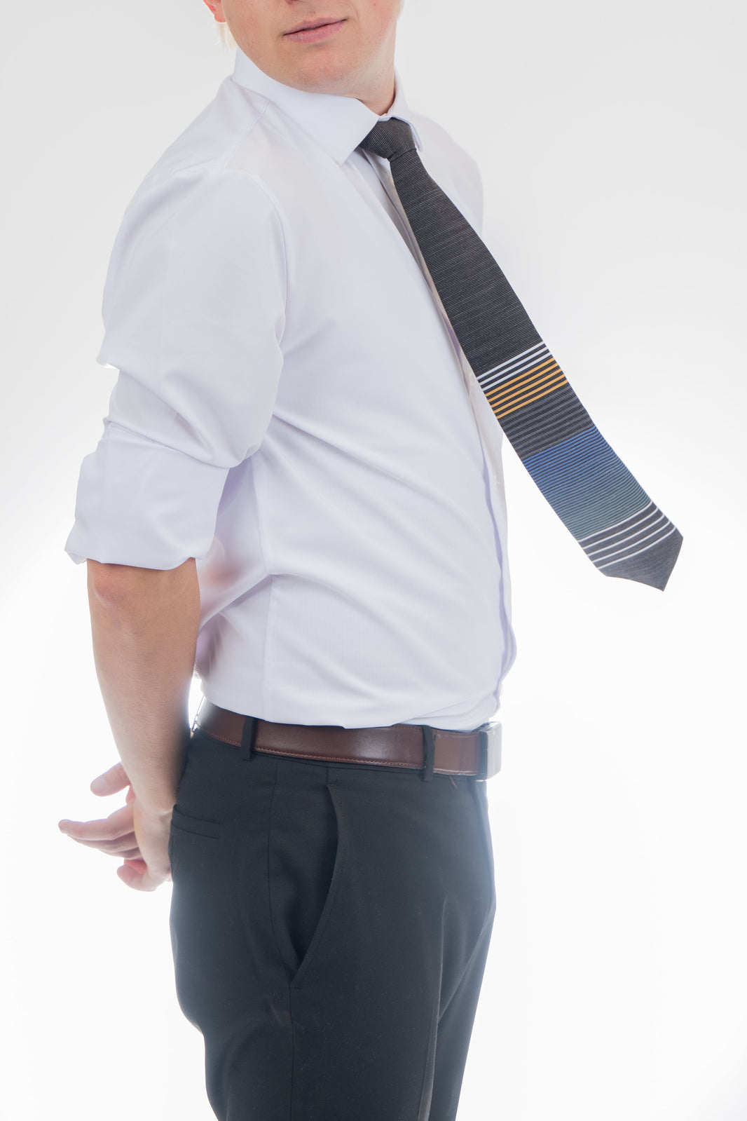 A man wearing a cool, modern, striped blue and yellow necktie. Missionary Tie handcrafted by Kator Shop – refined Utah menswear piece built to elevate any formal look in Cache Valley.