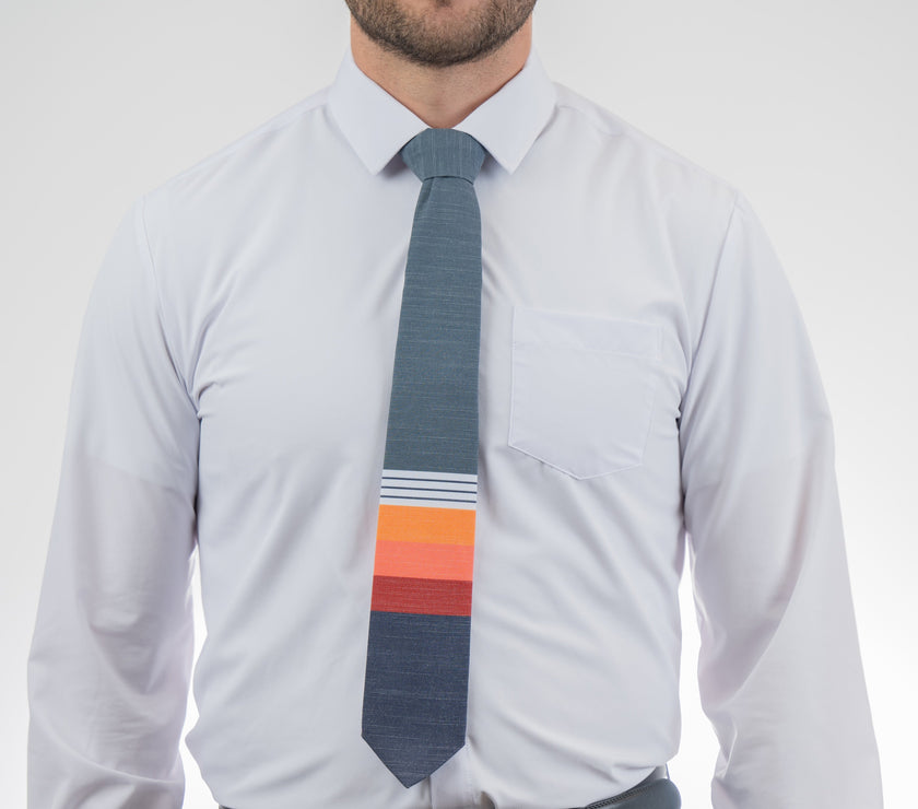 Man wearing a modern, cool necktie with thick, color blocked stripes of yellow, peach, and red