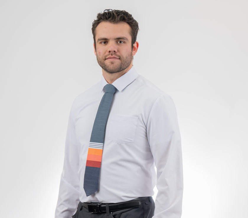 Man wearing a modern, colorful, cool necktie with thick, color blocked stripes of yellow, peach, and red
