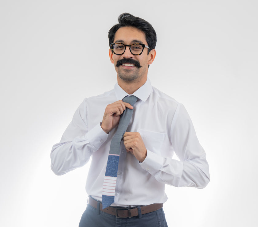A man wearing a gray, pink, and blue necktie with stripes and topography lines pattern Tie from Kator Shop in Logan, Utah – high-quality men’s accessory made for timeless style and confidence.