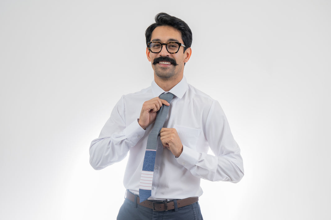 A man wearing a gray, pink, and blue necktie with stripes and topography lines pattern Tie from Kator Shop in Logan, Utah – high-quality men’s accessory made for timeless style and confidence.