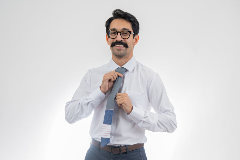 A man wearing a gray, pink, and blue necktie with stripes and topography lines pattern Tie from Kator Shop in Logan, Utah – high-quality men’s accessory made for timeless style and confidence.