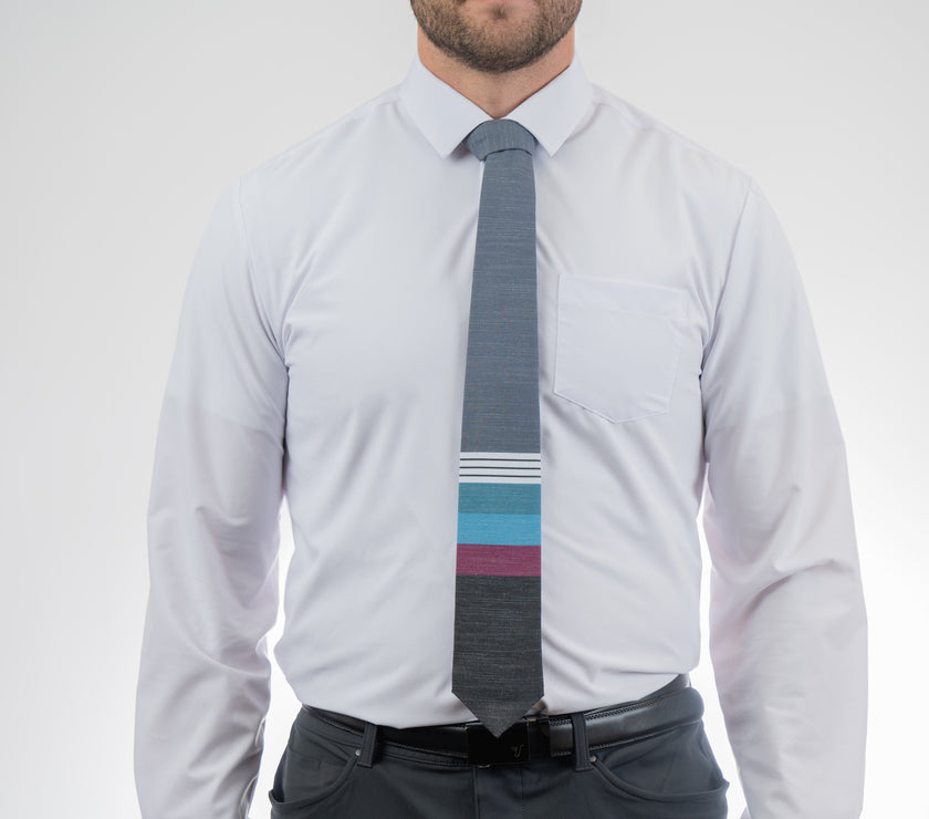 A man wearing a cool, modern necktie with thick purple, green, turquoise stripes