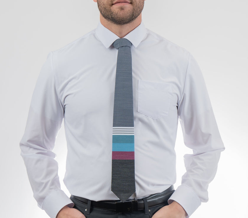 A man wearing a cool, modern necktie with thick purple, green, turquoise stripes
