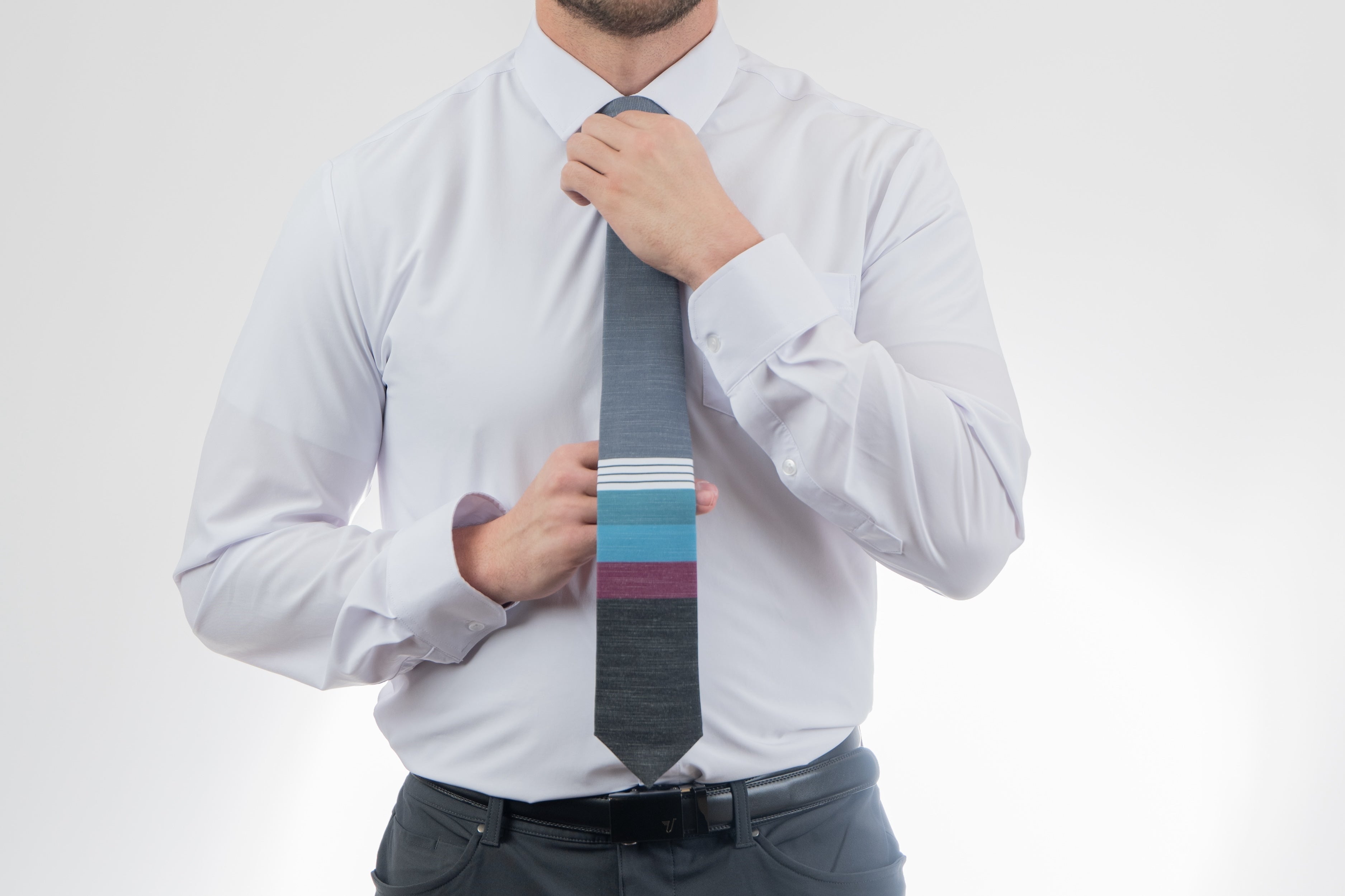 A man wearing a cool, modern necktie with thick purple, green, turquoise stripes