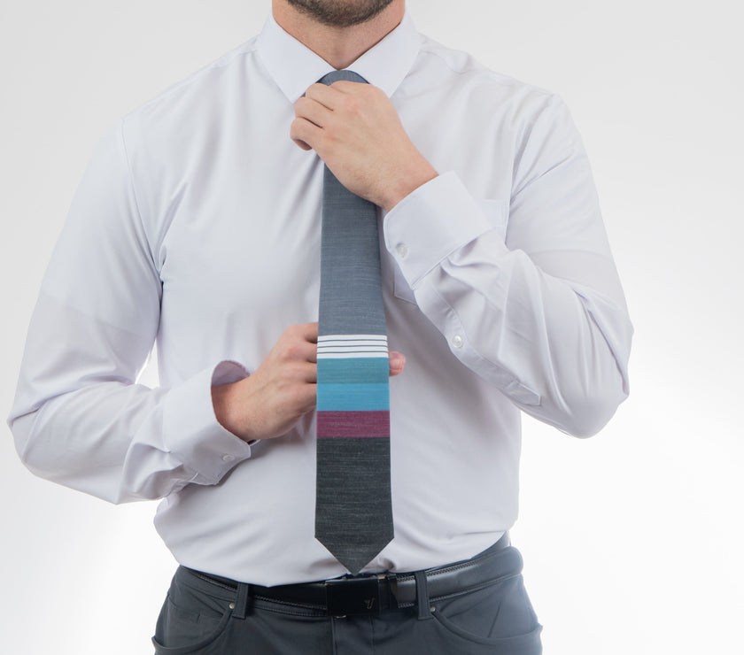 A man wearing a cool, modern necktie with thick purple, green, turquoise stripes