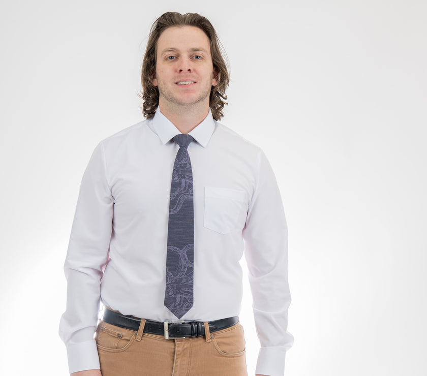 A man wearing a cool, modern, blue necktie with an octopus on it
