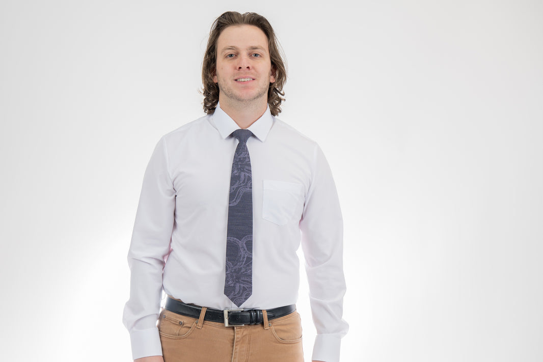 A man wearing a cool, modern, blue necktie with an octopus on it