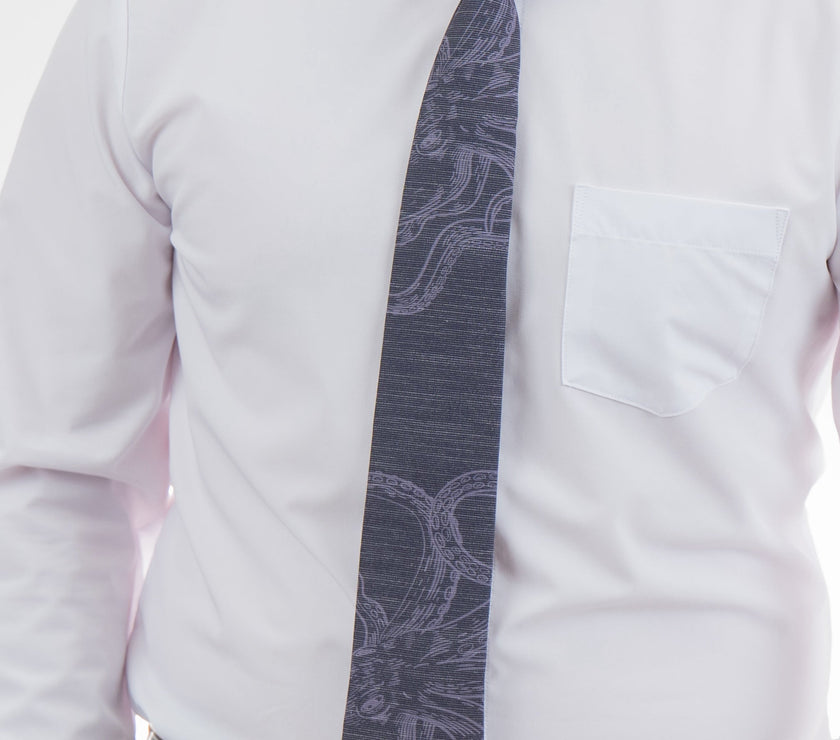 A man wearing a cool, modern, blue necktie with an octopus on it
