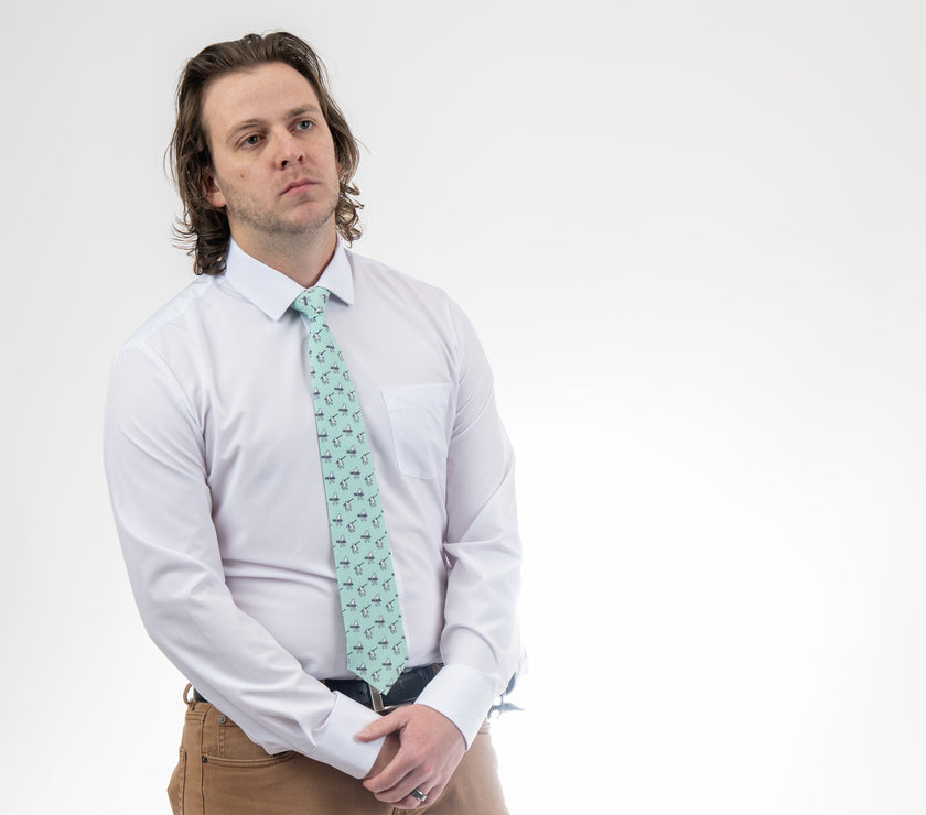 A man wearing a necktie with yetis, skis, and snowboarding