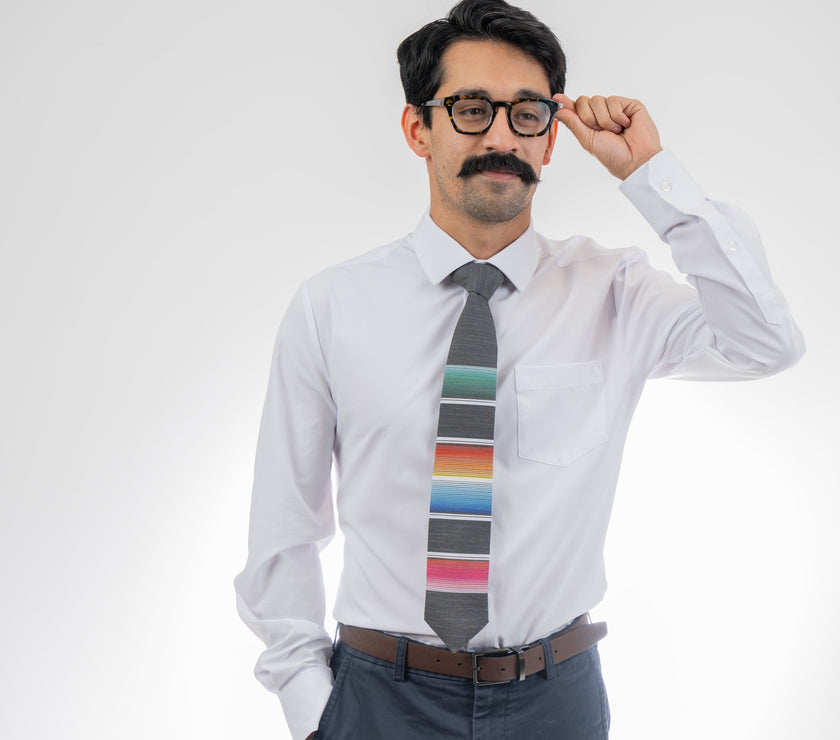 A man wearing a cool, modern necktie with colorful stripes in the style of a Mexican blanket 