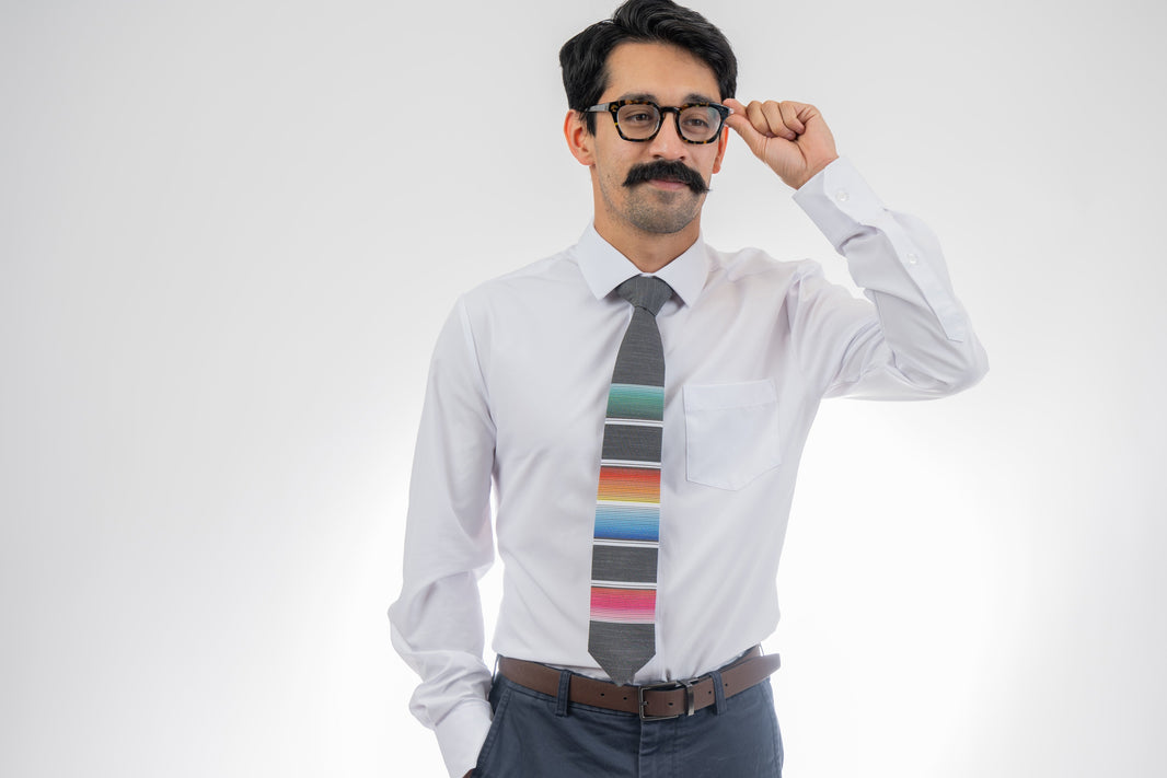 A man wearing a cool, modern necktie with colorful stripes in the style of a Mexican blanket 