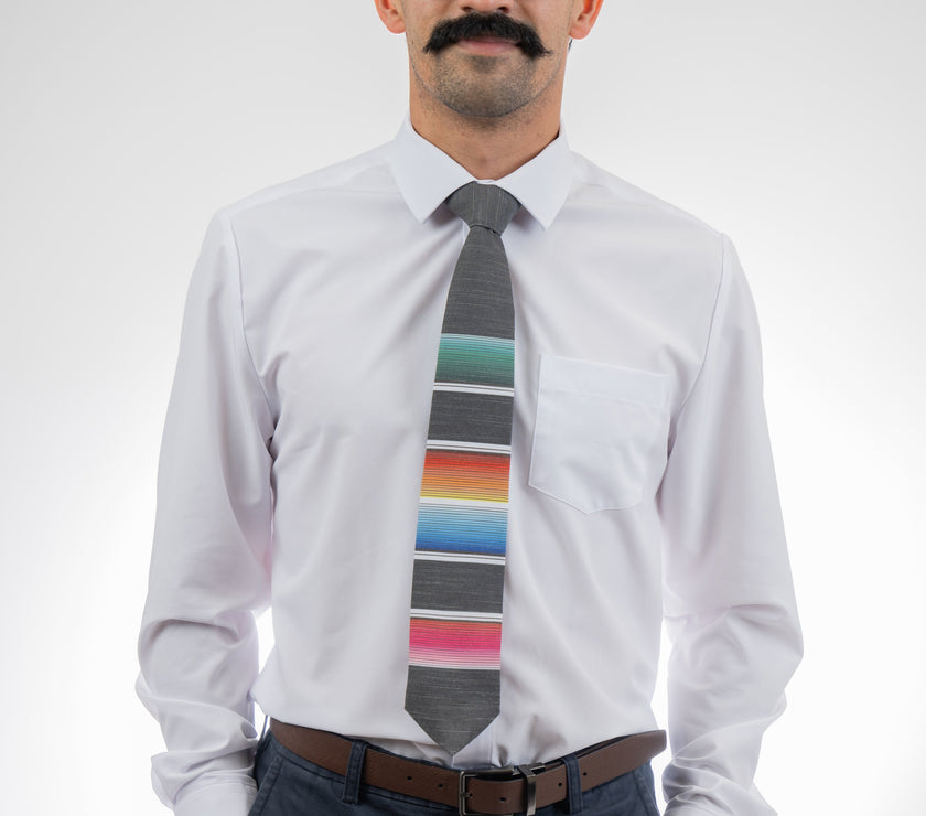 A man wearing a cool, modern necktie with colorful stripes in the style of a Mexican blanket 