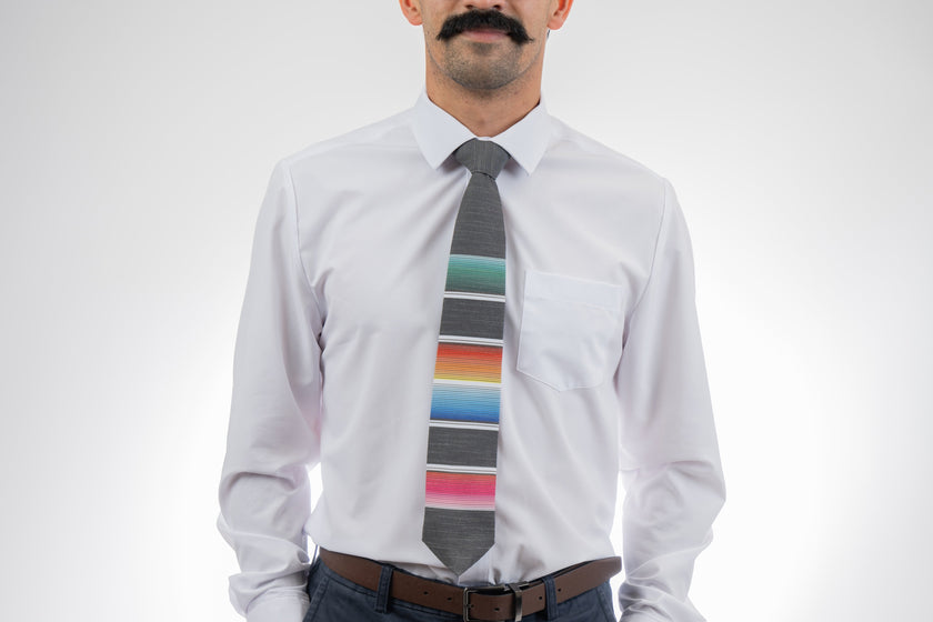 A man wearing a cool, modern necktie with colorful stripes in the style of a Mexican blanket 