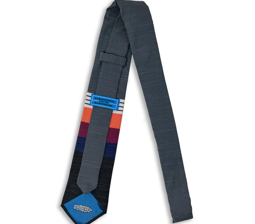 A cool, modern necktie with thick coral, purple, and blue stripes