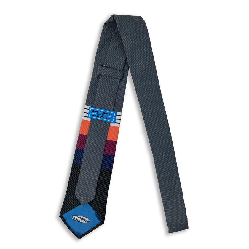 A cool, modern necktie with thick coral, purple, and blue stripes