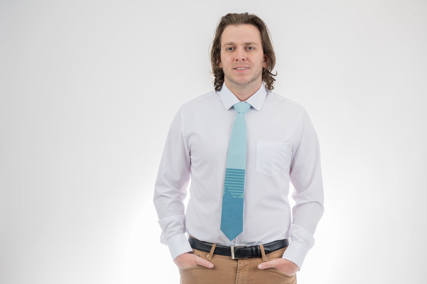Man wearing a turquoise mountain tie with stripes. Casual tie designed by Kator Shop — perfect balance of relaxed and refined for Cache Valley men’s fashion.