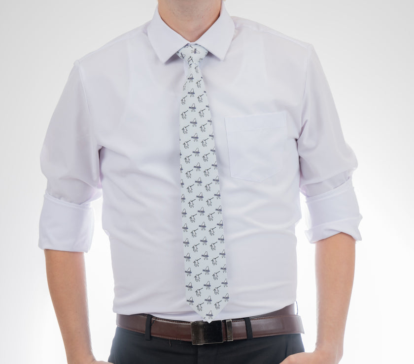 A man wearing a necktie with yetis, skis, and snowboards. Business tie from Kator Shop in Logan, Utah — premium material designed for confidence and all-day comfort at work.