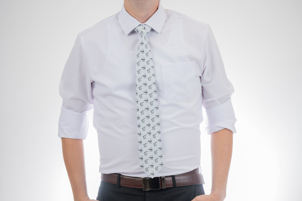 A man wearing a necktie with yetis, skis, and snowboards. Business tie from Kator Shop in Logan, Utah — premium material designed for confidence and all-day comfort at work.