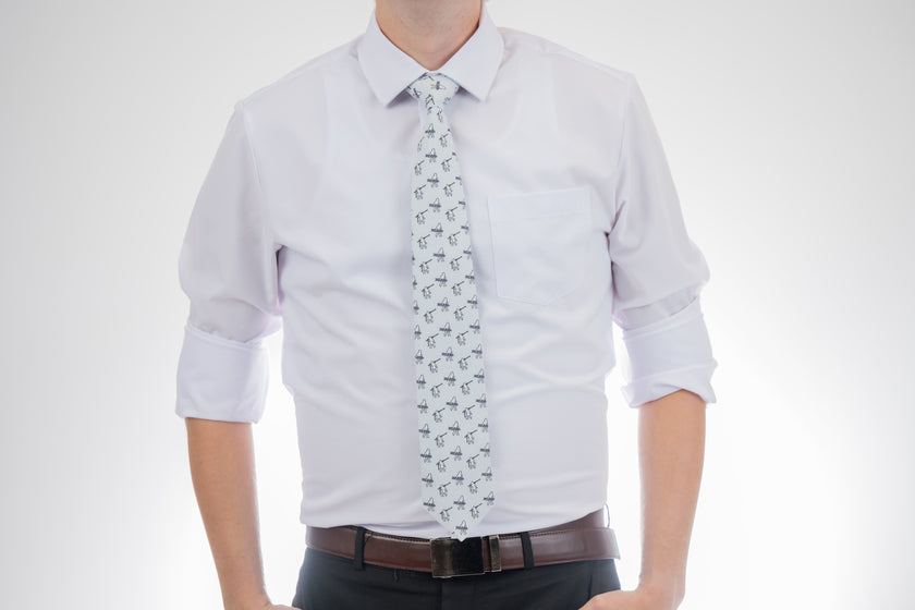 A man wearing a necktie with yetis, skis, and snowboards. Business tie from Kator Shop in Logan, Utah — premium material designed for confidence and all-day comfort at work.