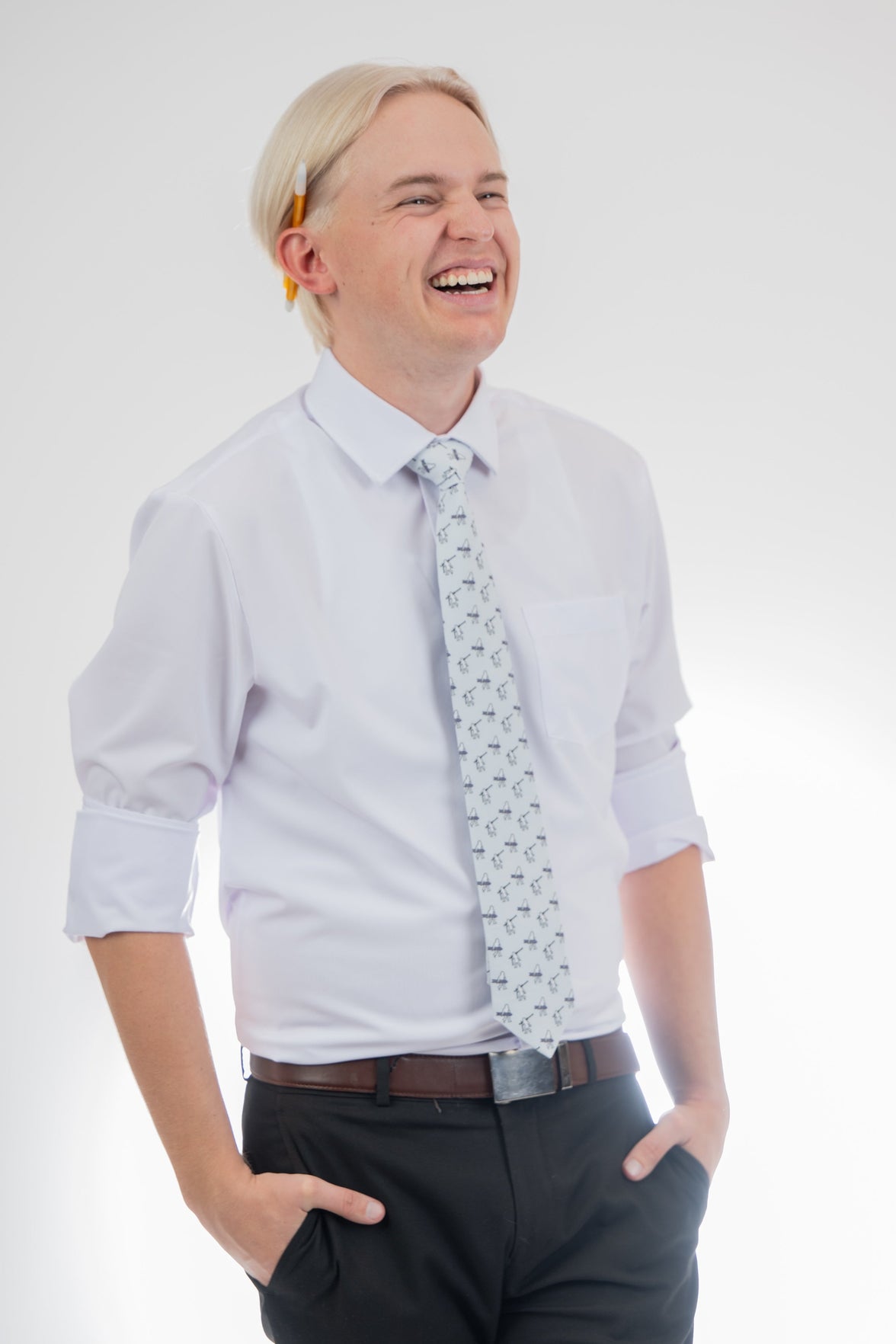 A man wearing a necktie with yetis carrying skis and snowboards, Sharp prom tie from Kator Shop in Logan, Utah — bold color and luxury texture for a standout prom night look.
