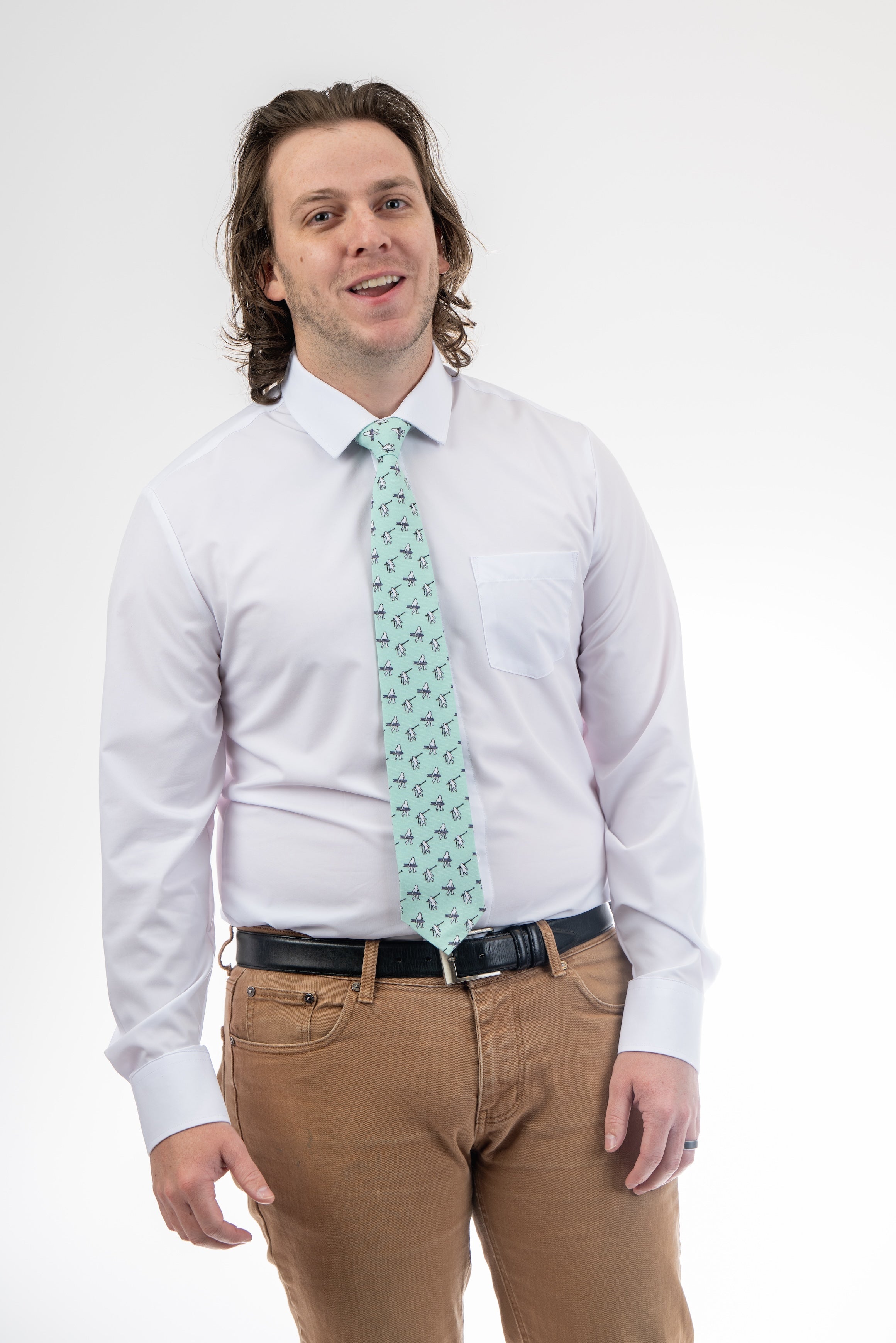 A man wearing a necktie with yetis, skis, and snowboarding. Business tie from Kator Shop in Logan, Utah — premium material designed for confidence and all-day comfort at work.