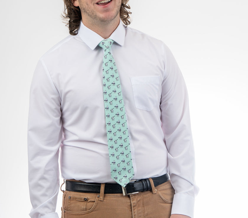 A man wearing a necktie with yetis, skis, and snowboarding. Business tie from Kator Shop in Logan, Utah — premium material designed for confidence and all-day comfort at work.