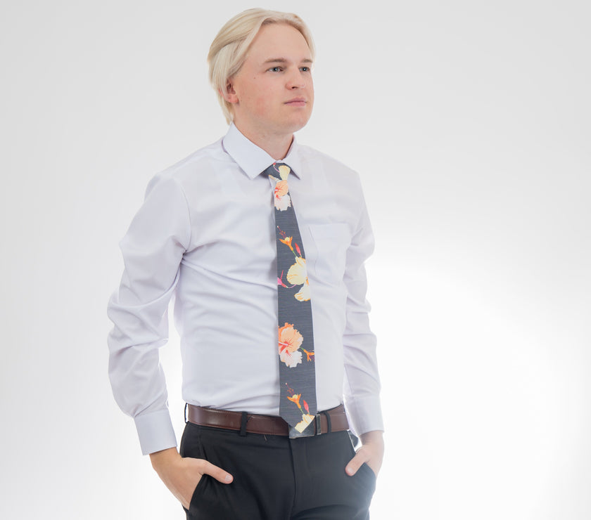 A man wearing a gray necktie with tropical floral pattern. Business tie from Kator Shop in Logan, Utah — premium material designed for confidence and all-day comfort at work.