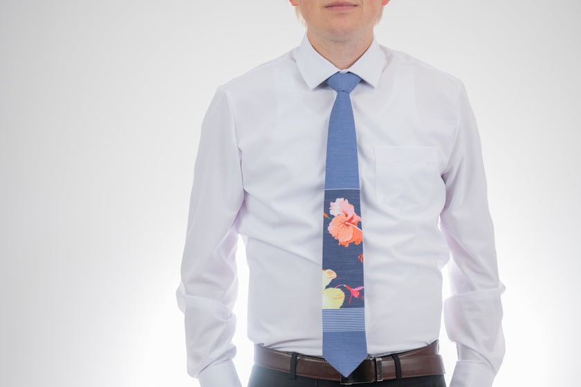 Sky Hibiscus Panel Men's Tie. Man wearing a modern, tropical floral necktie. Formal tie from Kator Shop Logan — refined Utah design for galas, church events, and special celebrations.