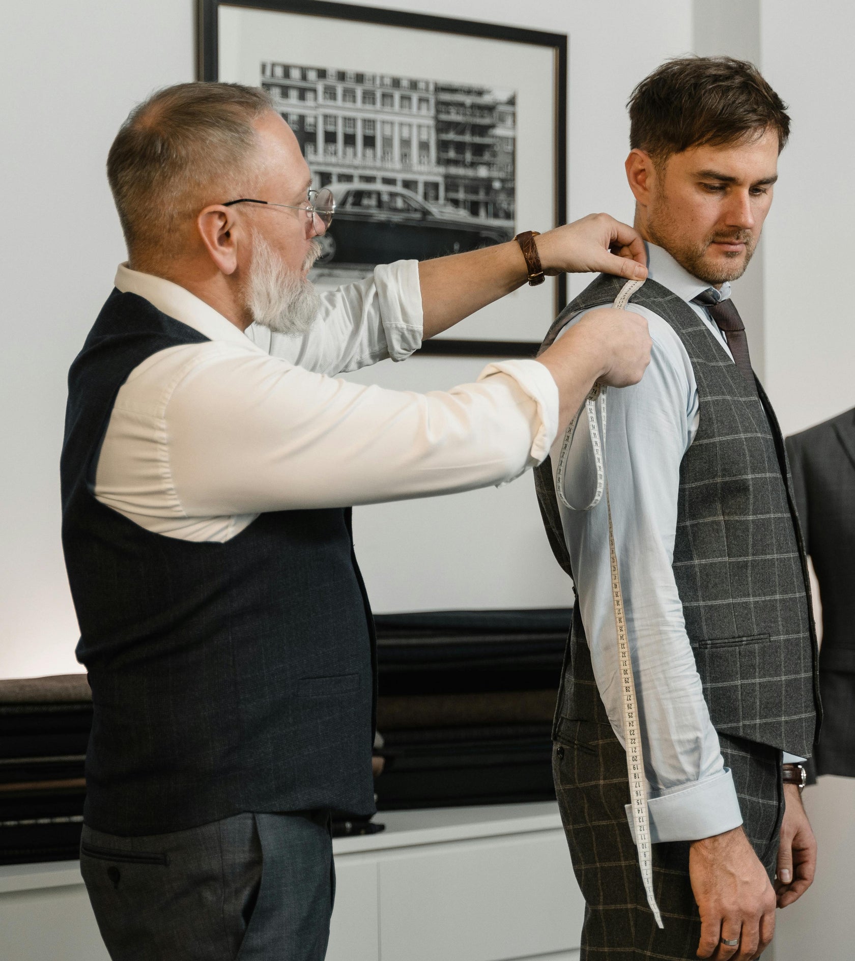 Tailor measuring a client for a custom suit in Logan, Utah at Kater Shop.